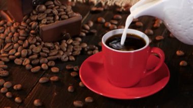 Küçük kırmızı fincan espresso içinde süt veya krema dökülür