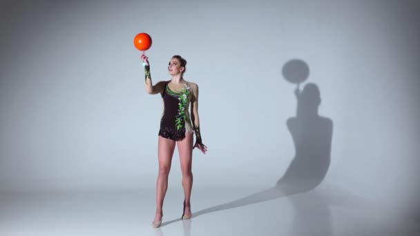 Gymnast professional spinning a ball on one finger. White background. Slow motion — Stock Video
