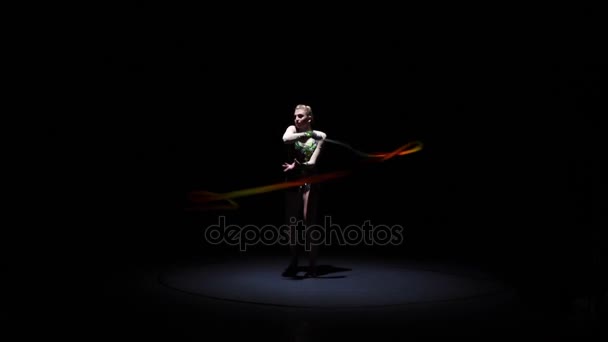Flexible gymnast with tape creates beautiful hands graceful movements. Black background. Slow motion — Stock Video