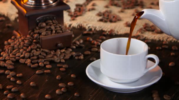 Чёрный горячий кофе наливают в белую чашку из кофейника — стоковое видео