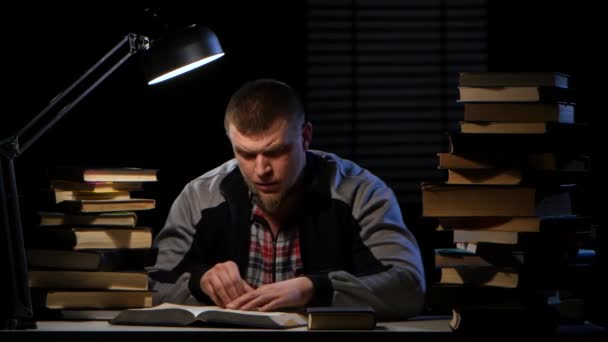 Adam okuma, bilgi bulma masada oturan ve mutlu. Siyah arka plan — Stok video