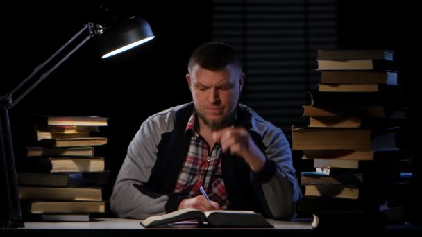 Kerl im Licht der Lampe liest er furchtbar Kopfschmerzen. schwarzer Hintergrund — Stockvideo