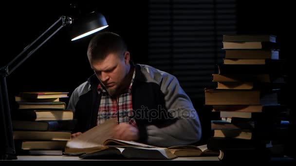 Guy looking for the right information in the book and could not find it. Black background — Stock Video