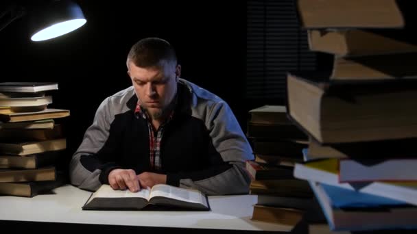 Un uomo in cerca di informazioni sfogliando il libro. Fondo nero — Video Stock