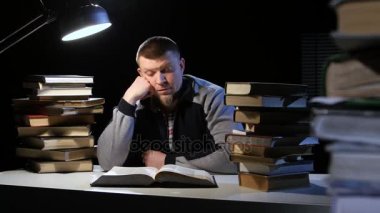 Çocuk kitap okur ve masaya uyuya kalır. Siyah arka plan
