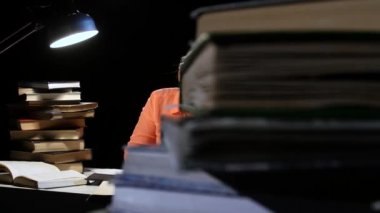 Kız okur ve bilgi bir defterde yazar. Siyah arka plan