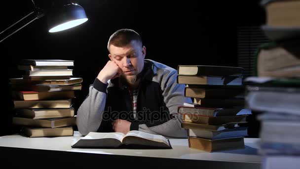 Jongen leest het boek en valt in slaap op de tafel. Zwarte achtergrond — Stockvideo