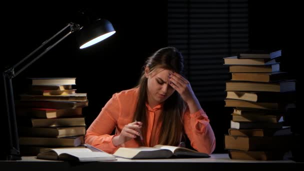 La ragazza sfoglia il libro e fa male il mal di testa. Fondo nero — Video Stock