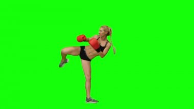 Kız kick boks kadar atlar ve değişim ve tekmeler yapar. Yeşil ekran. Yan görünüm
