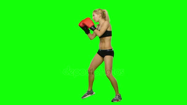 Girl kickboxer in a special form of training for competitions. Green screen. Side view — Stock Video