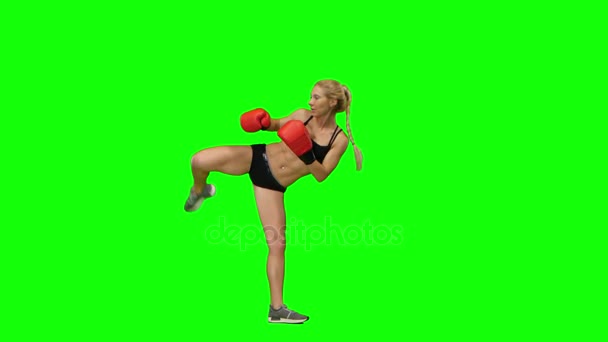 Flicka kickboxer hoppar upp och gör gungor och sparkar. Grön skärm. Sidovy — Stockvideo