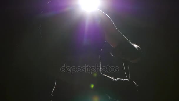 Boxer pulls in his arms protective bandages. Silhouette. Black background . Side view. Close up — Stock Video