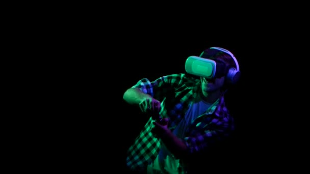 Man plays on gamepad in virtual reality glasses. Green light — Stock Video