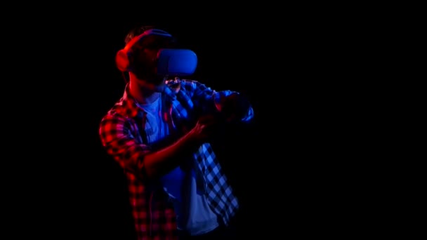 Man plays on gamepad in virtual reality glasses. Red light — Stock Video