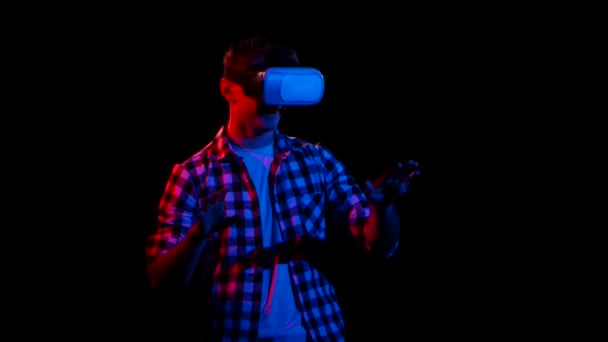 In virtual reality glasses man moves hands. Dark studio — Stock Video