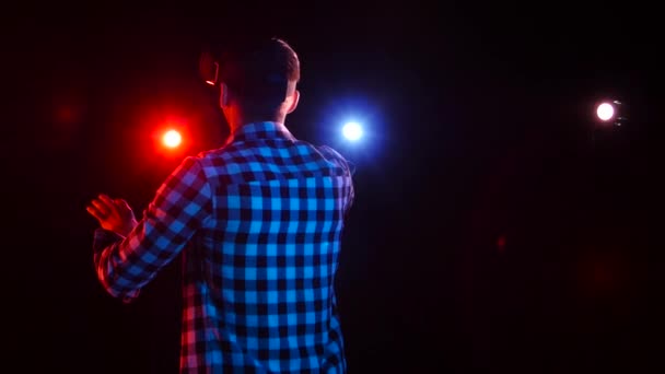 Dark studio with floodlights. Man gamer in virtual reality glasses — Stock Video