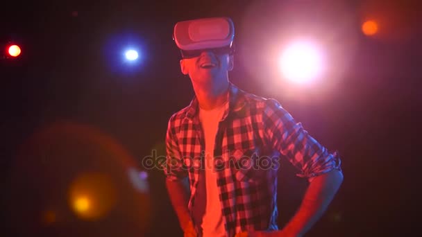 Hombre con deleite viendo en gafas de realidad virtual. Proyectores rojos — Vídeos de Stock