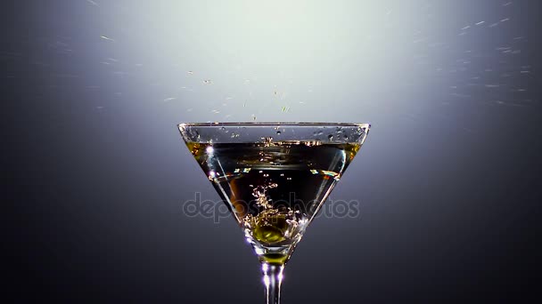 Green fresh olives fall into glass with cocktail. Slow motion — Stock Video