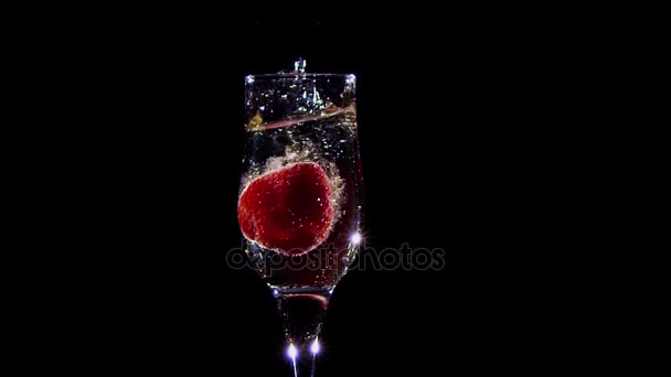 Al rallentatore. Fragola fresca che cade in vetro con vino champagne — Video Stock