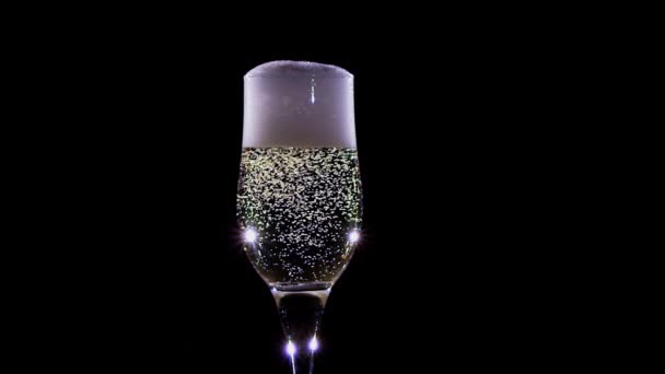 Пузырьки шампанского, сверкающие в бокале. Медленное движение — стоковое видео