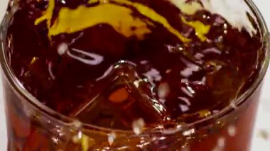 Ağır çekim. Viski ile cam içine düşen iki buz küpleri