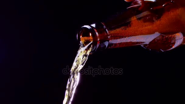 Beer is poured from dark glass bottle and ends. Closeup — Stock Video