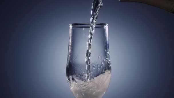 Le vin de Champagne est versé dans un gobelet en verre transparent. Fond bleu 