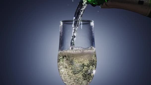 Vino de champán se vierte en vaso de vidrio transparente de la botella — Vídeos de Stock