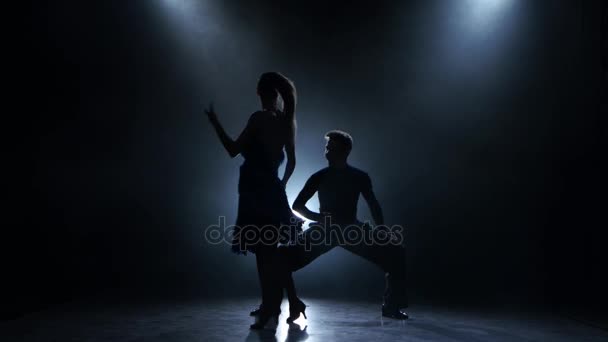 Professionele paar rumba dansers poseren in rokerige studio, silhouet — Stockvideo