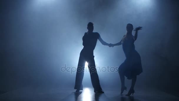 Dance cha-cha-cha performed by professional couple in smoky studio, silhouette — Stock Video