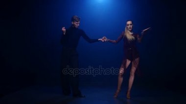 Mavi arka plan üzerinde çift profesyonel zarif dansçıların dans tango