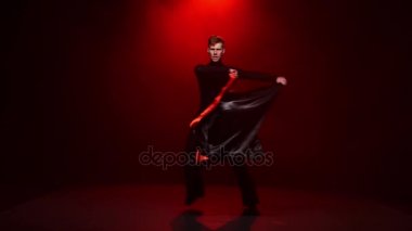 Kırmızı arka plan. Adam kırmızı siyah bezle solo dans ediyor