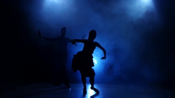 Силуэт пары танцоров, исполняющих современный танец в дымчатой студии — стоковое видео