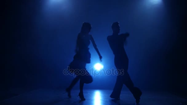 Silhouette de deux danseurs dansant en latino dans un studio fumé — Video