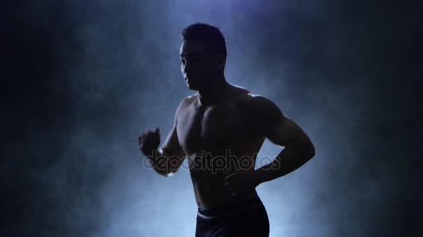 Silhouet sportman uitvoeren op zwart backround. Geïsoleerde rokerige studio — Stockvideo