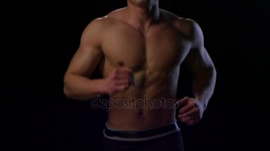 Ağır çekimde siyah arka plan üzerinde çalışan adam atlet. Stüdyo