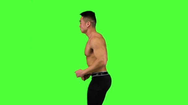 Man running on a green screen background, in slow motion — Stock Video