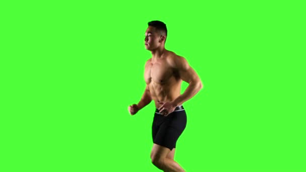 Hombre corriendo sobre fondo de pantalla verde, cámara lenta. Vista lateral — Vídeo de stock