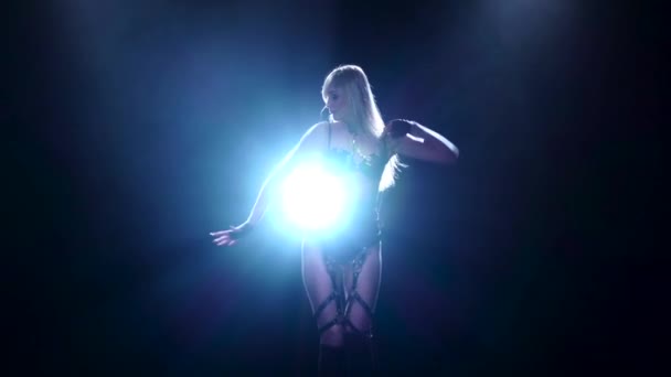 Vrouw dansen op de achtergrond van de schijnwerper, slow-motion — Stockvideo