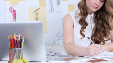 Tasarımcısı çizimler onun atölye ve gülümsüyor yeni bir kadın koleksiyonunda çizer