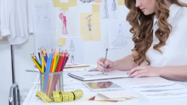 Modedesignerin zeichnet Skizzen für neue Kollektion und blickt auf den Computer — Stockvideo