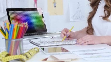 Sanatçı onun çalışma odasında oturur, yeni bir koleksiyon skeçler. Yakın çekim