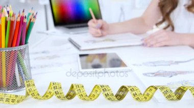 Sanatçı onun çalışma odasında oturur, yeni bir koleksiyon skeçler. Yakın çekim