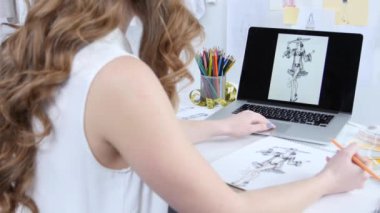 Sanatçı ofisinde, kızlar için yeni bir kıyafet bir kroki çizmek