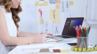 Tasarımcı bilgisayar bakar ve tonları giyim yeni bir koleksiyon için seçer