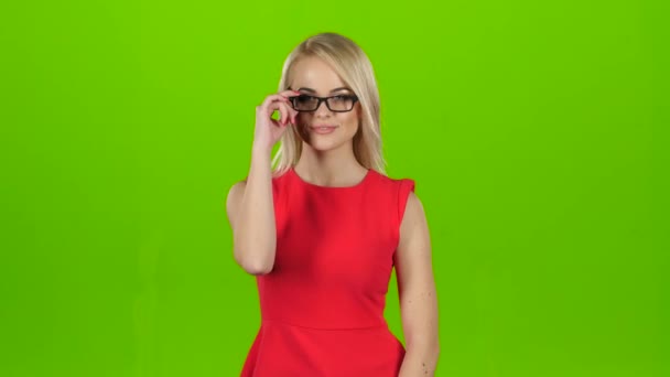 Guapa rubia guiña los ojos de gafas, estudio de pantalla verde — Vídeo de stock