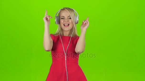 Sexy chica en vestido rojo bailando en auriculares, cámara lenta — Vídeo de stock