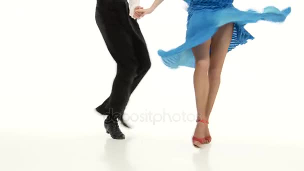 Legs of pair professional ballroom dancers perform rumba, white background