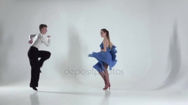 Çift beyaz zemin üzerine gölge rumba dans ediyor. Ağır çekim