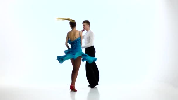 Пара чемпіонів танцюристи виконують ромбу, повільний рух. Біла студія — стокове відео